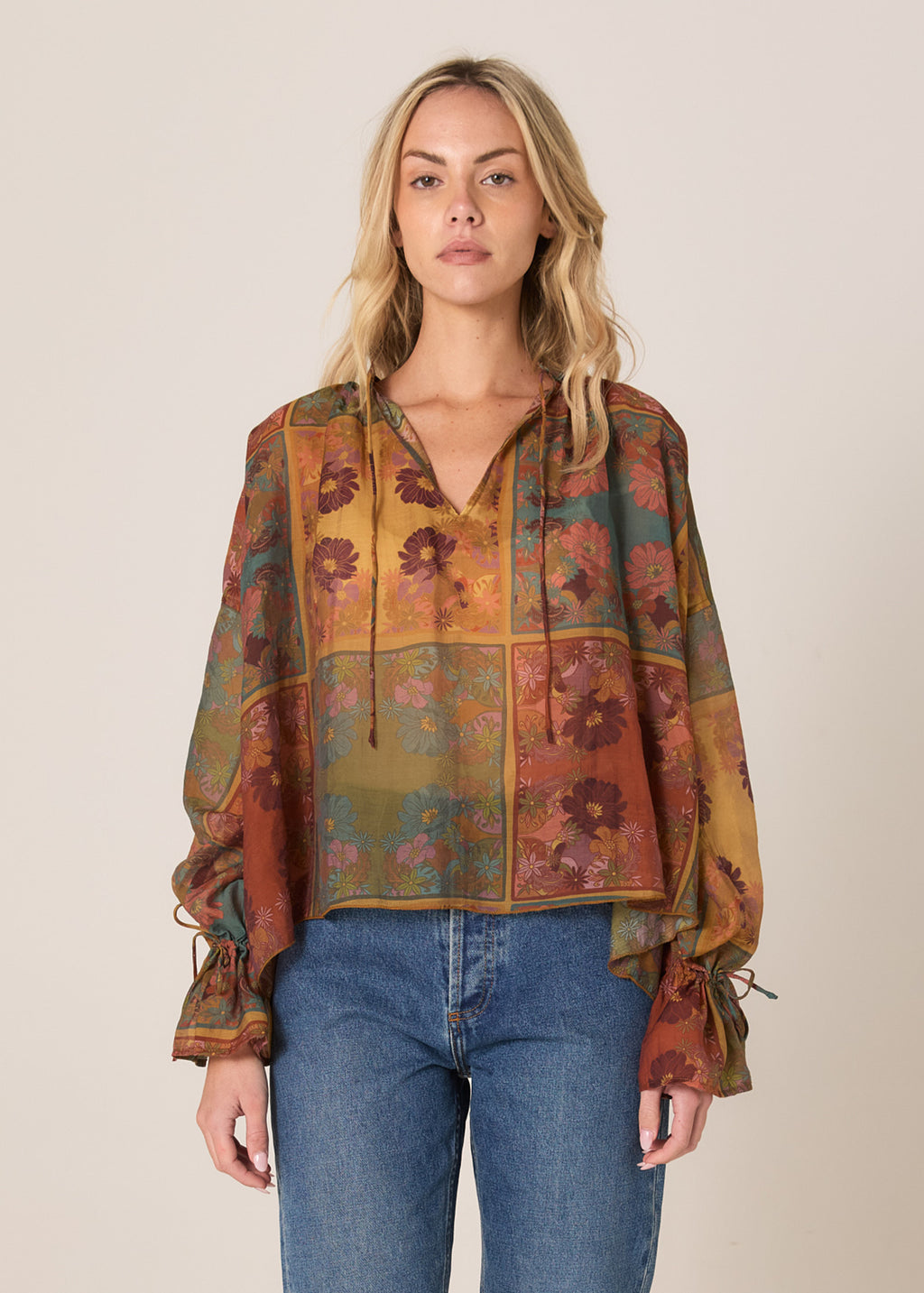 Woman wearing a patterned blouse and blue jeans on a beige background
Bohemian Top Nouveau Floral Green