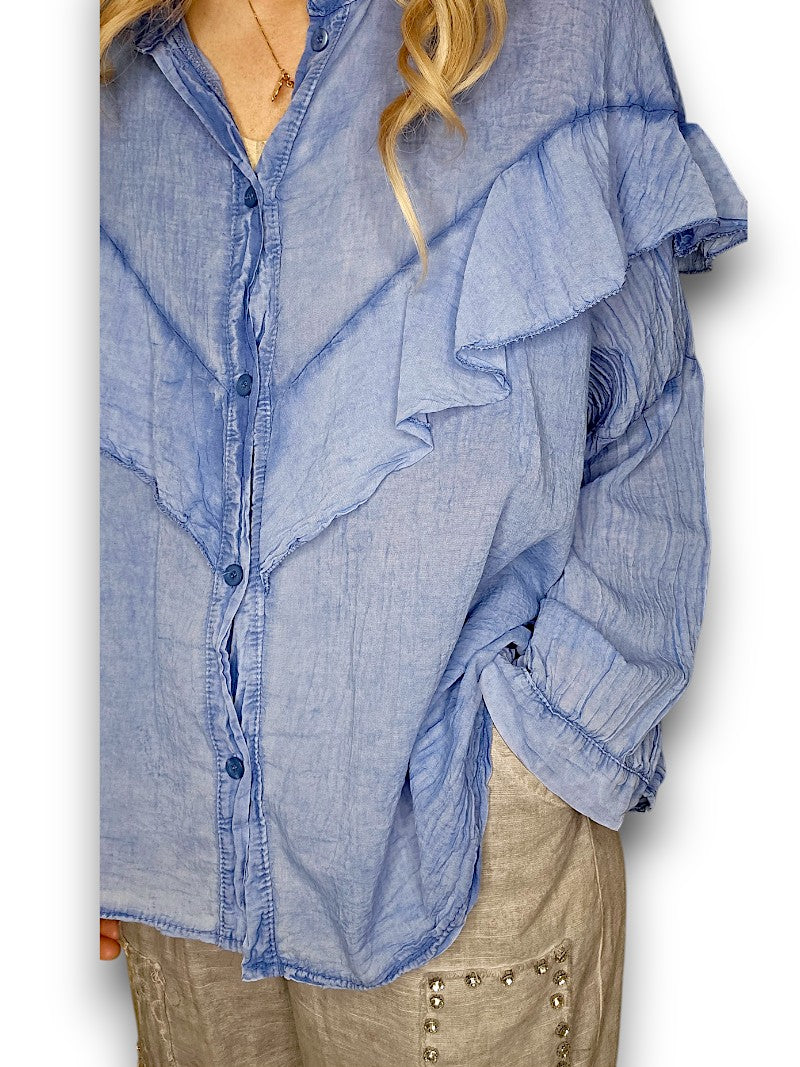 Woman wearing a blue shirt and gray pants on a white background
Frill Tunic Denim Blue