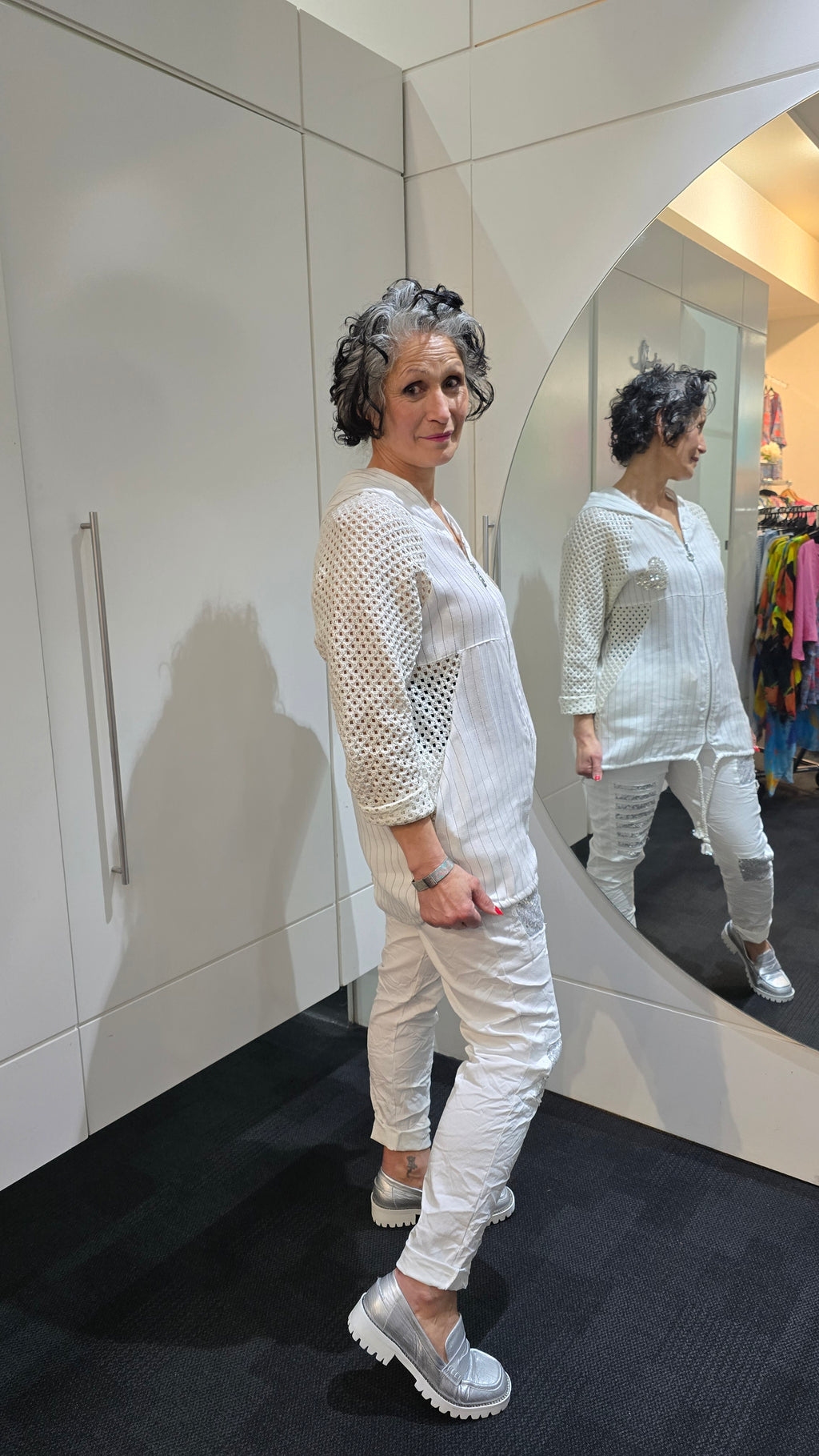 Woman in a white outfit standing in front of a mirror in a store.
Italian Seq Pants White