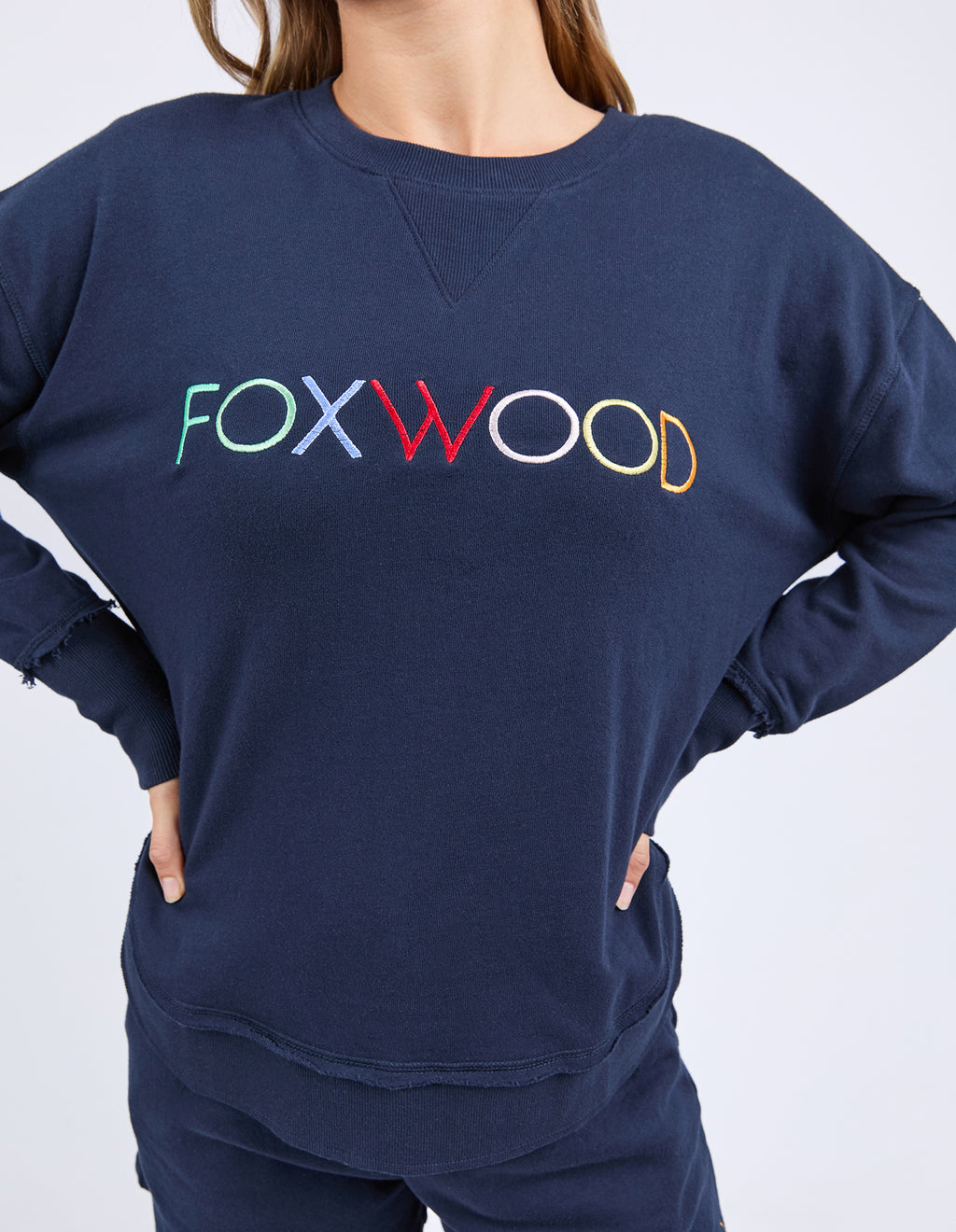 Woman wearing navy sweatshirt and shorts with 'FOXWOOD' branding on a white background
Simplified Confetti Crew Navy