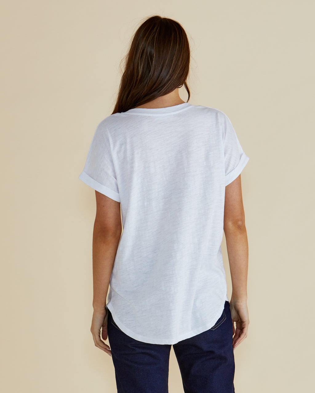 Woman wearing a white t-shirt with colorful floral design and 'Campo de Fiori' text on a beige background