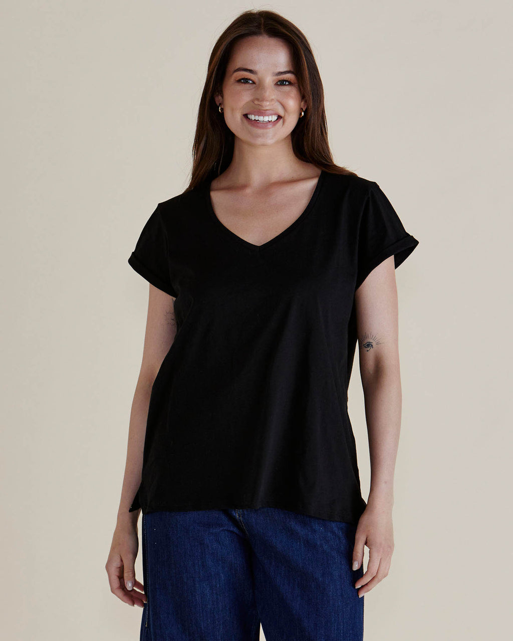 Woman wearing a black top and blue jeans against a beige background
Ayla V-Neck Tee Black
