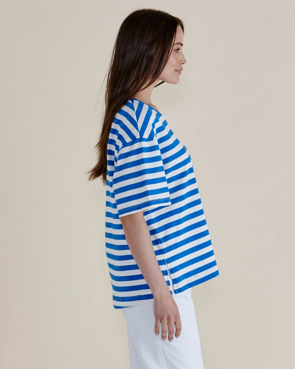 Woman wearing a blue and white striped shirt against a plain background