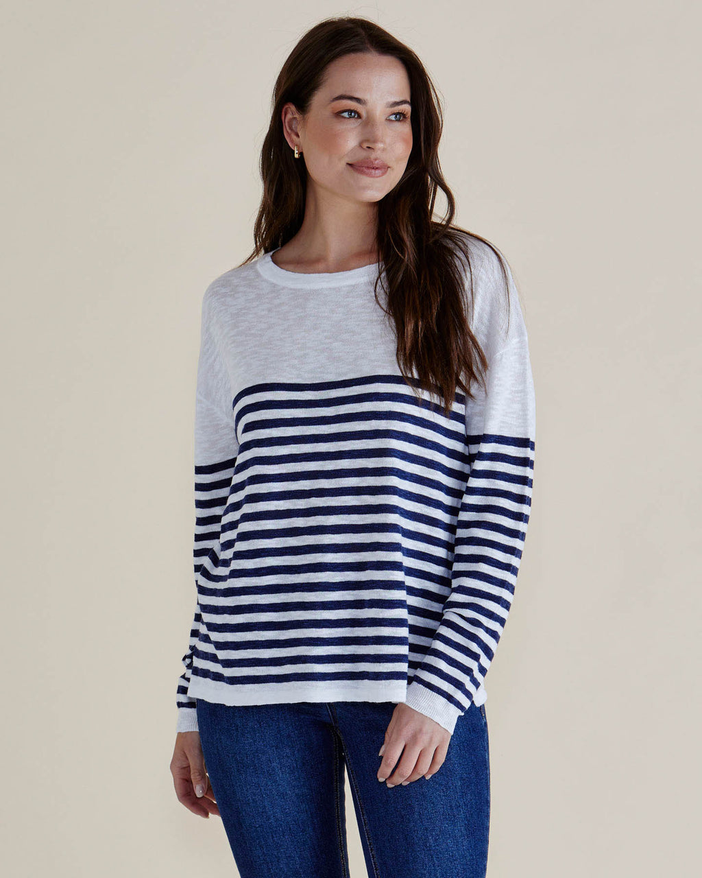 Woman wearing a navy and white striped sweater with blue jeans on a plain background
Natasha Knit Top White/Navy