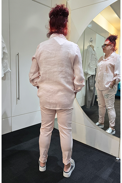 Person wearing a light-colored outfit with ripped jeans in front of a mirror.
Italian Hey Sequin Shirt Pink