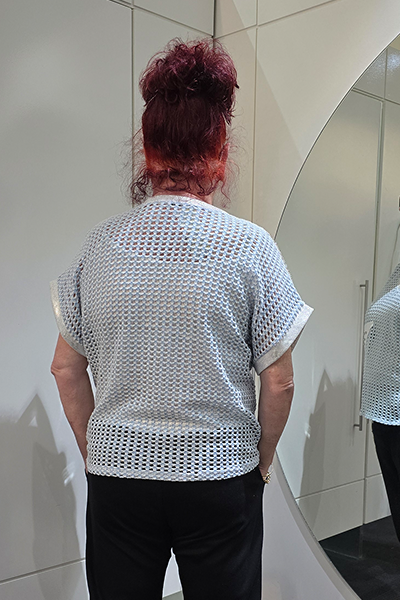 Person wearing a light gray mesh top with black pants, standing in front of a mirror.
Italian Metallic Stars Top Blue