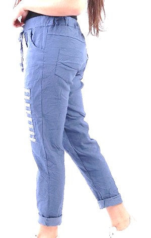 Woman wearing blue distressed jeans and a black top on a white background