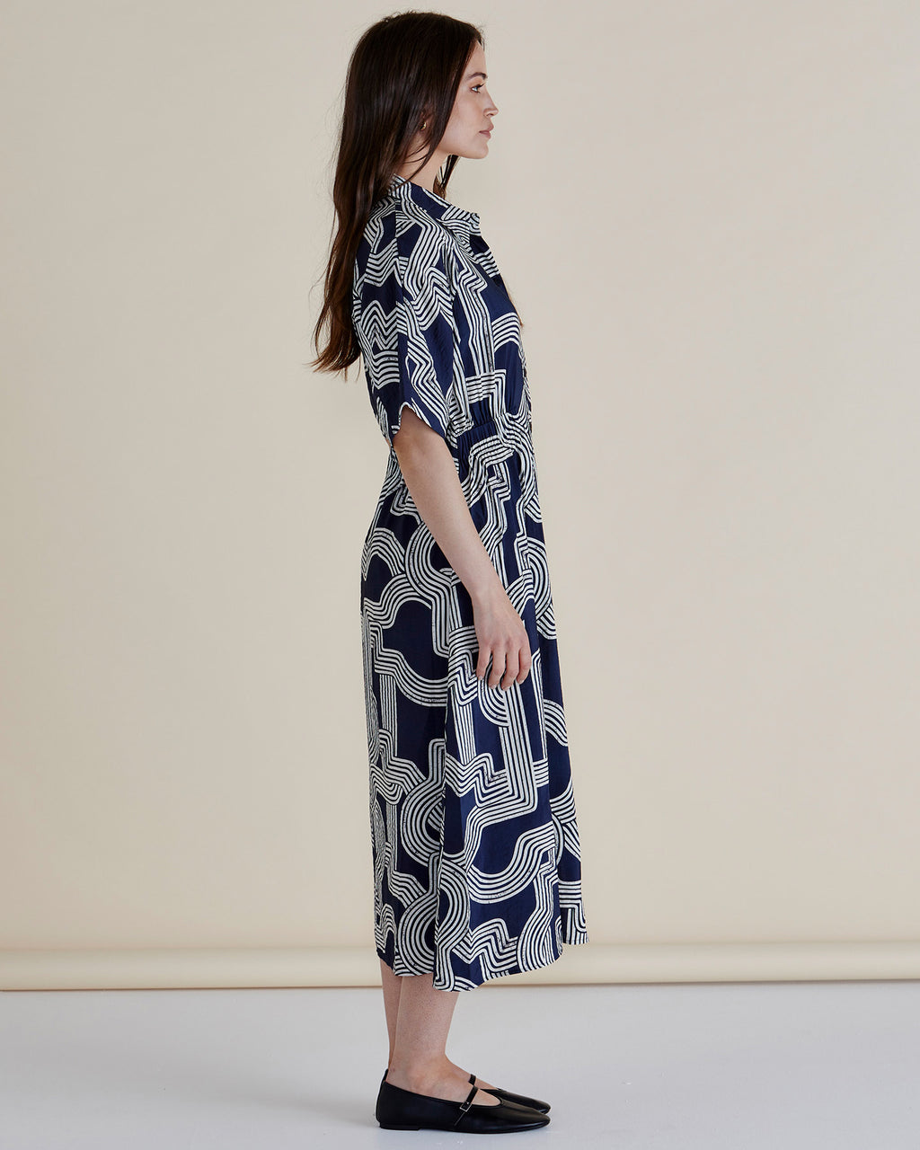 Woman wearing a patterned dress against a plain background