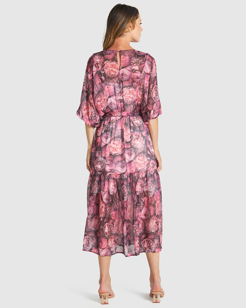 Woman wearing a pink floral dress on a white background