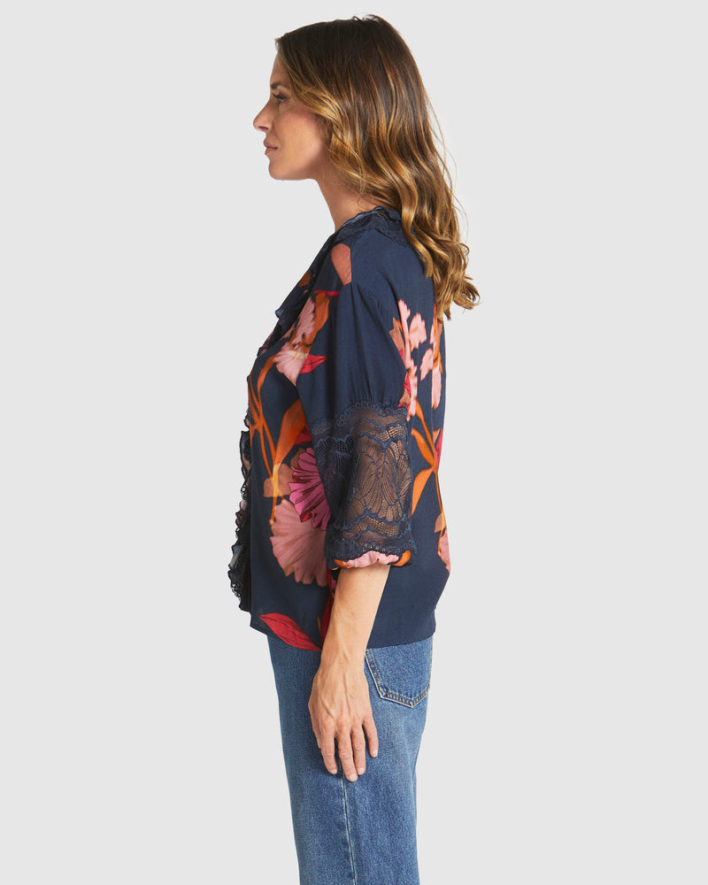 Woman wearing a dark floral patterned top and jeans on a white background
Captivation Shirt Navy Floral