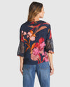 Woman wearing a floral blouse with lace sleeves on a white background
Captivation Shirt Navy Floral