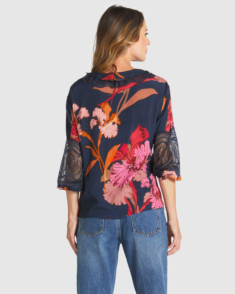 Woman wearing a floral blouse with lace sleeves on a white background
Captivation Shirt Navy Floral