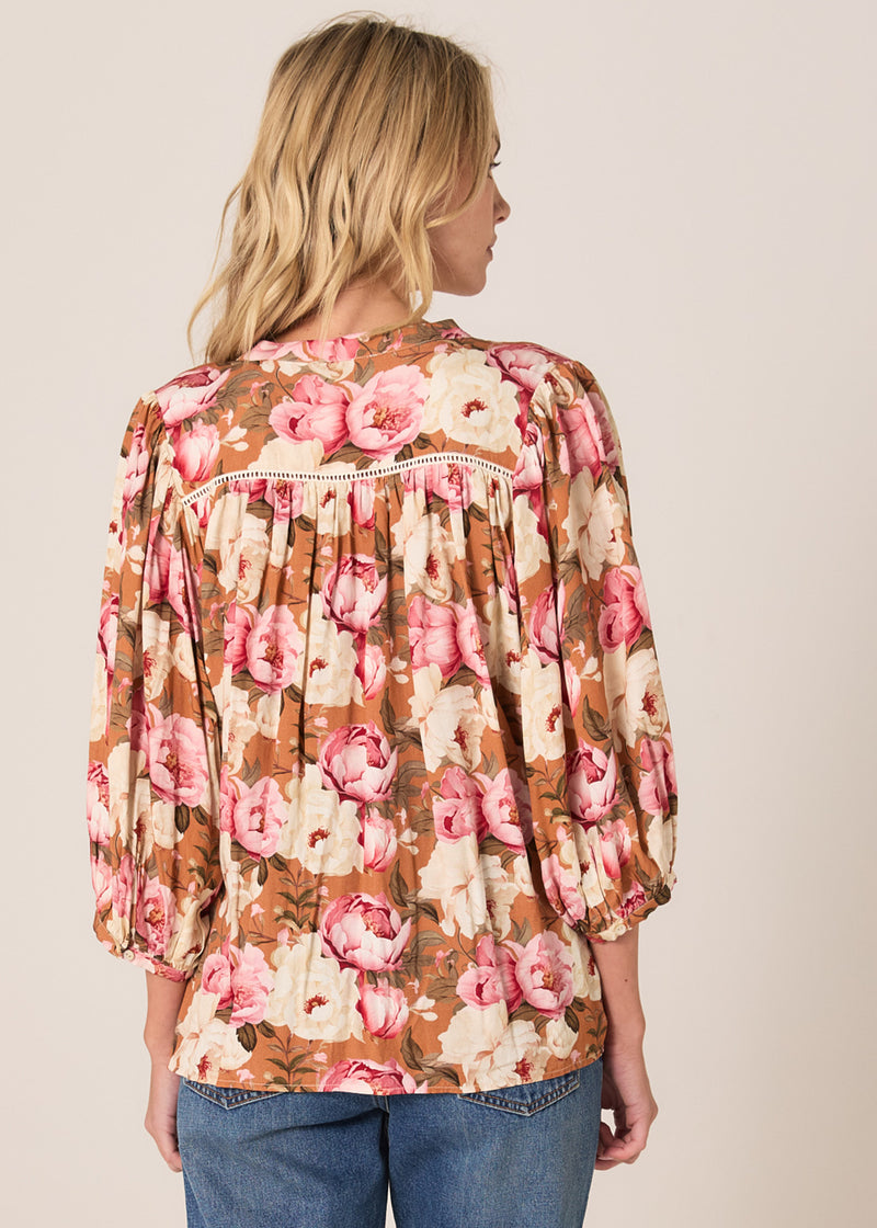 Woman wearing a floral blouse with a beige background
Sweet Emotion Top Garden Pink