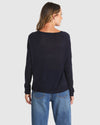 Person wearing a black long-sleeve top and blue jeans on a white background
Reminiscent Knit Navy
