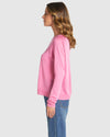Woman wearing a pink long-sleeve shirt and blue jeans on a light gray background
Reminiscent Knit Pink