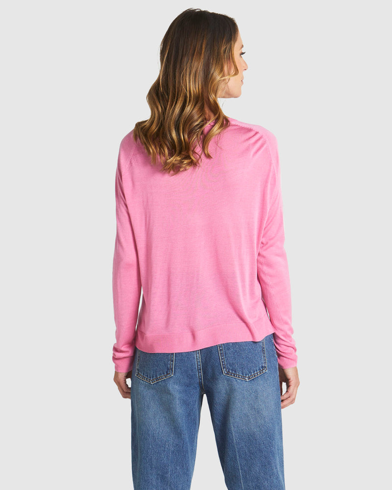 Person wearing a pink long-sleeve shirt and blue jeans on a white background
Reminiscent Knit Pink