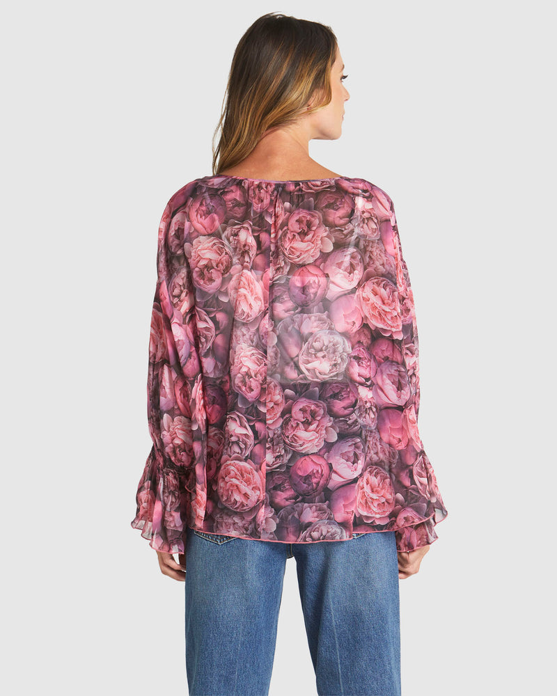 Woman wearing a floral blouse with long sleeves on a plain background
Phenomenon Blouse Peony Pink