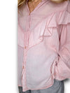 Pink ruffled blouse worn by a person on a white background
Frill Tunic Baby Pink
