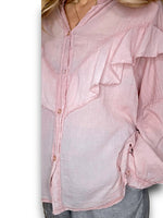Pink ruffled blouse worn by a person on a white background
Frill Tunic Baby Pink