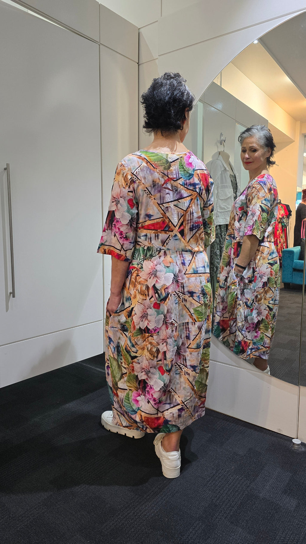 Two people wearing floral outfits standing in a kitchen. Round Neck Dress Multi
