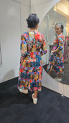 Person wearing a colorful patterned outfit standing in front of a mirror. Tie Front Dress Turquoise