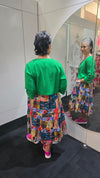 Person wearing a green top and colorful patterned skirt with a blurred background Crop Jacket Green