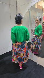 Person wearing a green top and colorful patterned skirt with a blurred background Crop Jacket Green
