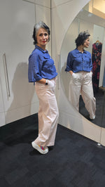 Person wearing a blue jacket and white pants standing in front of a mirror. Saffra Relax Leg Jean Pink