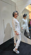 Person wearing a white outfit with a textured pattern, standing in front of a mirror.
Italian Seq Pants White