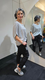 Woman standing in a store looking at herself in the mirror wearing a white shirt and black pants.
Italian Seq Pants Black