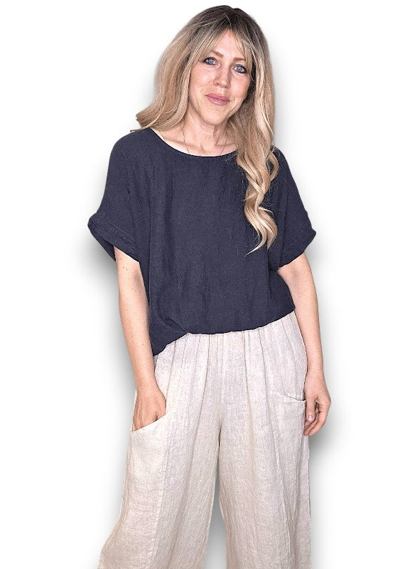 Woman wearing a navy blue top and light-colored pants on a white background Split Back River Tee Navy