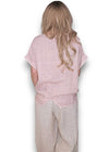 Person wearing a pink top and beige pants on a white background Split Back River Tee Baby Pink
