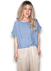 Woman wearing a blue top and beige pants on a white background Split Back River Tee Petrol
