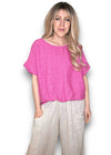 Woman wearing a bright pink top and light-colored pants on a white background Split Back River Tee Hot Pink