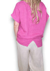 Person wearing a pink shirt and beige pants on a white background Split Back River Tee Hot Pink