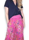 Woman wearing a navy top and pink floral pants on a white background Palazzo Doily Rose Pant Hot Pink