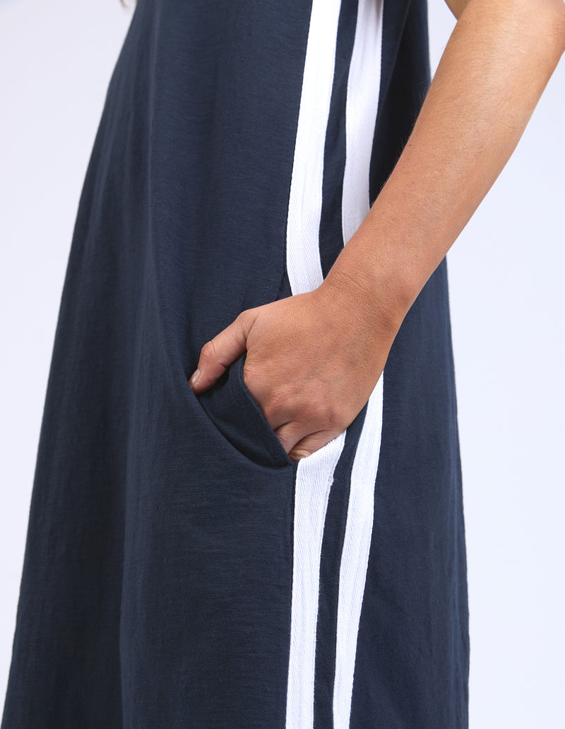 Navy blue dress with white stripes and a hand in a pocket on a light gray background
Recovery Dress Navy