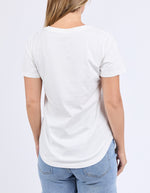 Person wearing a plain white t-shirt and blue jeans on a light gray background
Limoncello Tee Vintage White