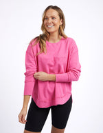 Woman wearing a pink sweatshirt with a brand logo on a white background
Simplified Crew Bright Pink
