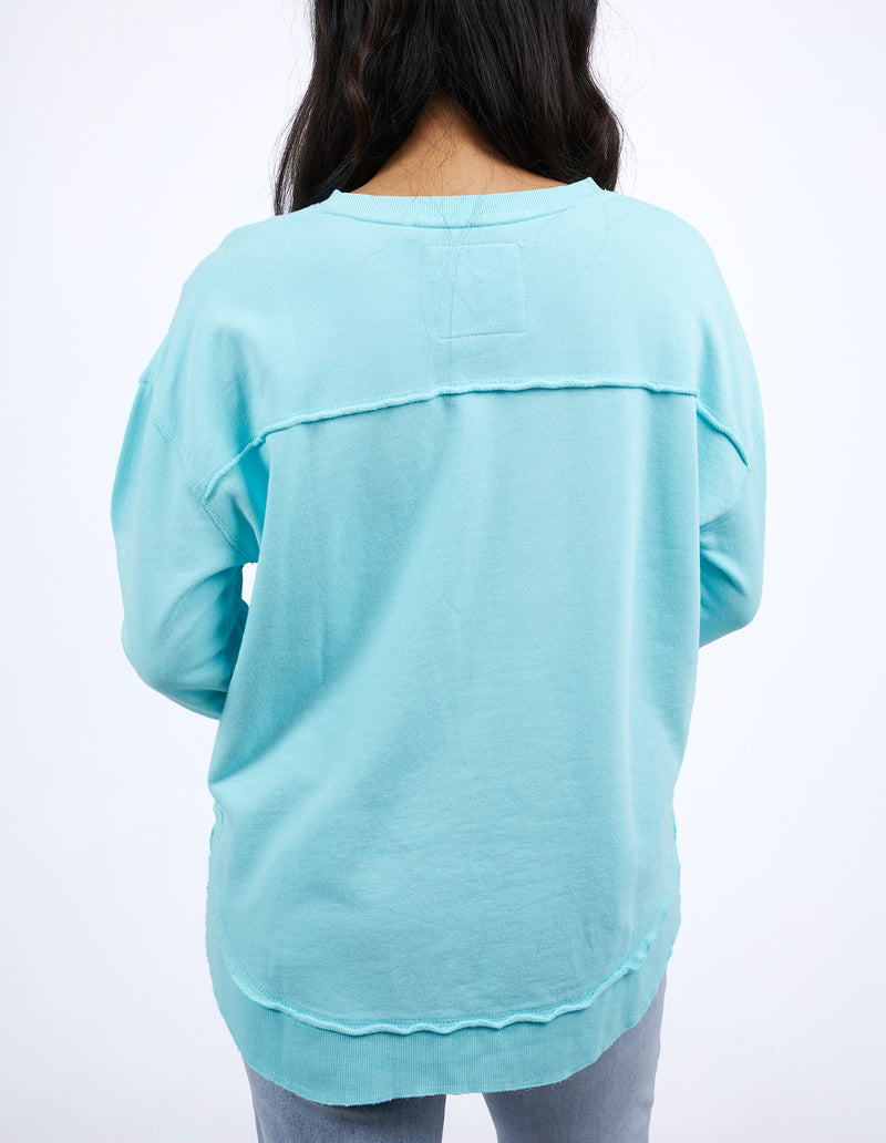Light blue long-sleeve top worn by a person on a white background
Simplified Crew Light Blue