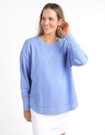 Woman wearing a light blue sweatshirt with 'FOXWOOD' branding on a white background
Simplified Crew Neon Blue