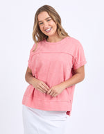 Woman wearing a pink top on a white background
Allison Tee Rose