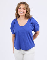 Woman wearing a blue top and white pants on a light gray background
The Grove Top Ocean Blue