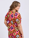 Woman wearing a colorful patterned dress on a white background
Rhode Top Geo Print