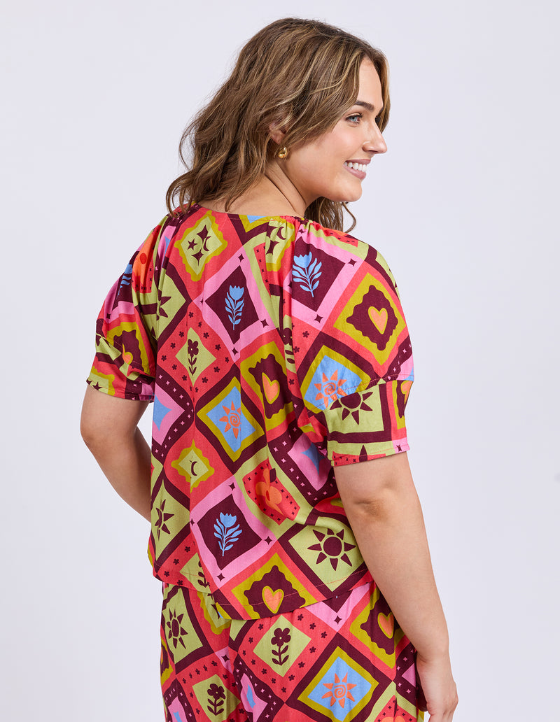 Woman wearing a colorful patterned dress on a white background
Rhode Top Geo Print