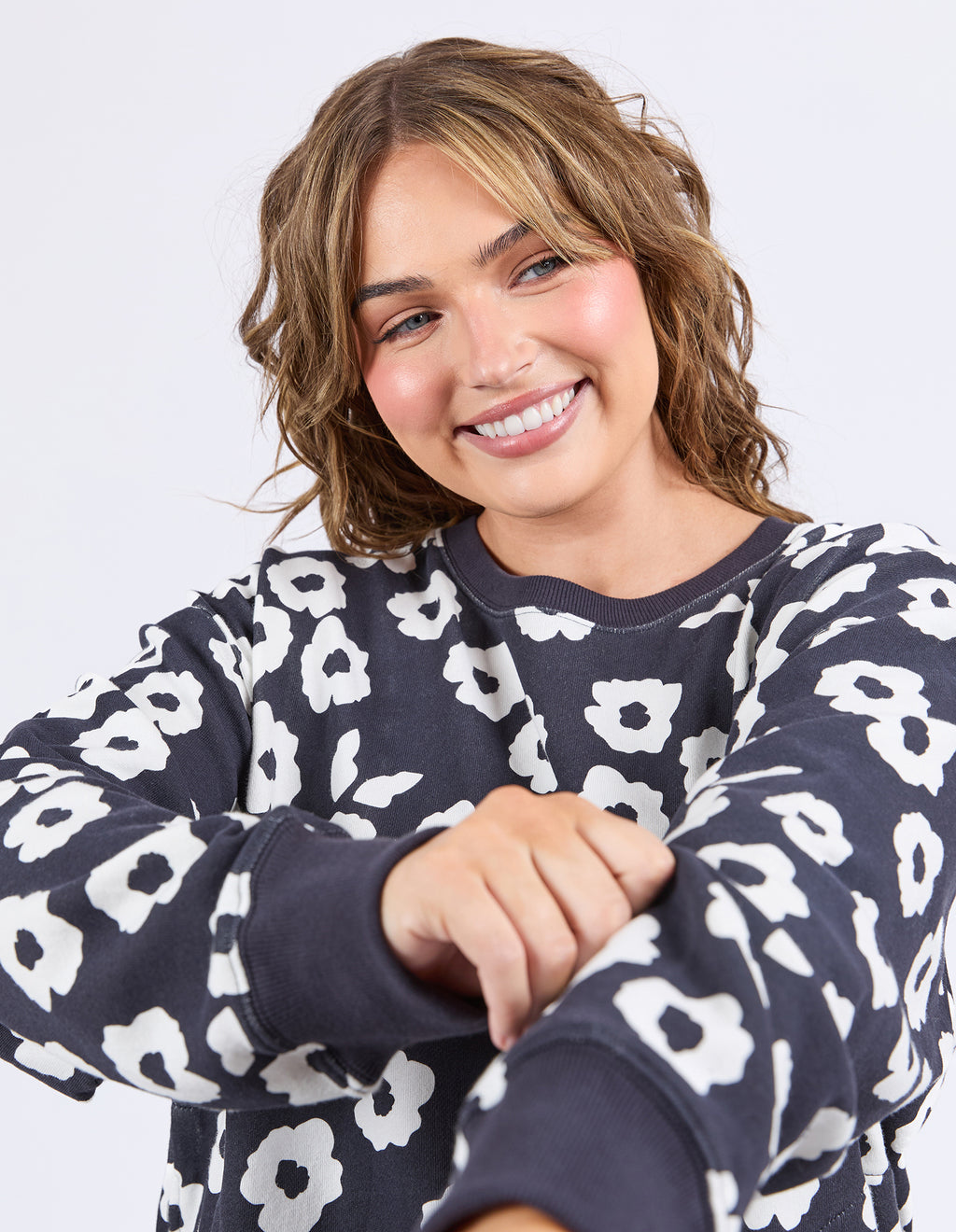 Woman wearing a navy blue sweatshirt with white floral pattern on a plain background
Azalea Crew Navy