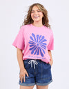 Woman wearing a pink t-shirt with a blue floral design and denim shorts on a white background
Camelia Tee Chateau Rose
