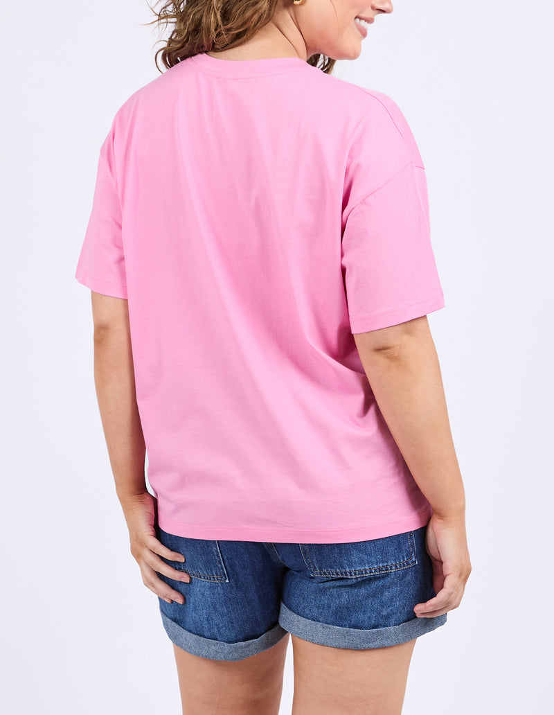 Person wearing a pink t-shirt and blue shorts on a light purple background
Camelia Tee Chateau Rose