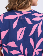 Navy blue t-shirt with pink leaf pattern worn by a person
Mimosa Tee Blue Depths