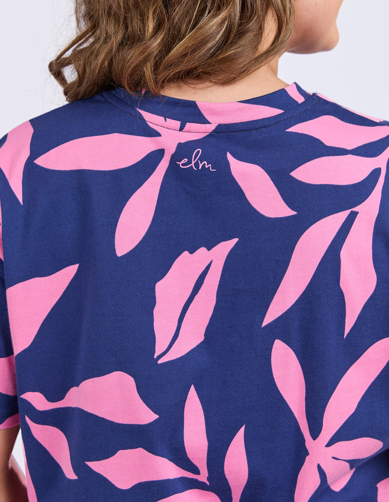 Navy blue t-shirt with pink leaf pattern worn by a person
Mimosa Tee Blue Depths